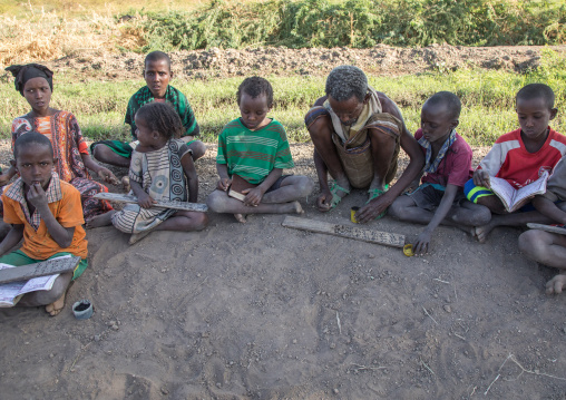 Afar tribe children in a coranic school writing on wood boards, Afar region, Afambo, Ethiopia