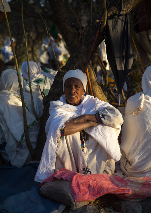 Ethiopian monk woman resting under a tree during Timkat epiphany festival, Amhara region, Lalibela, Ethiopia