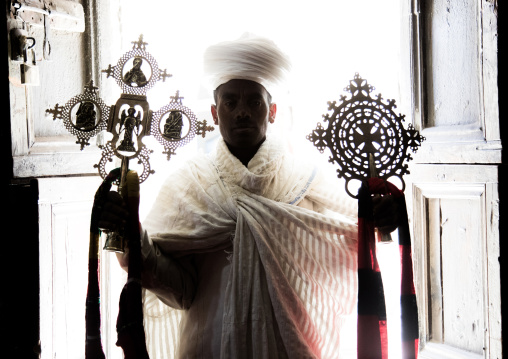 Portrait of an ethiopian orthodox priest holding crosses inside Asheten mariam rock hewn church, Amhara region, Lalibela, Ethiopia