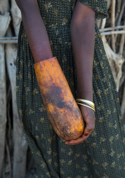 Amhara girl putting her hand in a calabash full of henna, Amhara region, Weldiya, Ethiopia