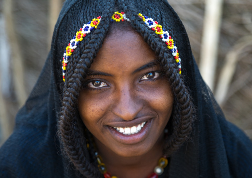 Portrait of a smiling Afar tribe girl with braided hair ands beaded headband, Afar region, Chifra, Ethiopia