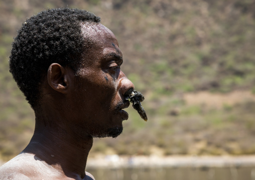 Borana tribe man with protection in his nose ready to dive in the volcano crater to collect salt, Oromia, El Sod, Ethiopia