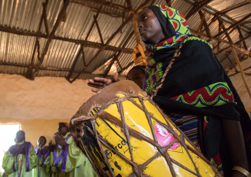 Borana woman playing drum during sunday church service, Oromia, Yabelo, Ethiopia