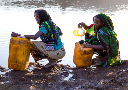 Borana tribe people filling jerricans in a water reservoir used for animals, Oromia, Yabelo, Ethiopia