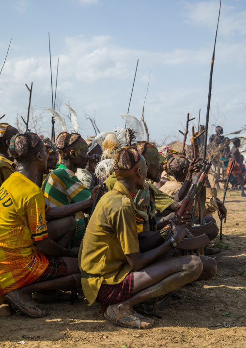 Tribe warriors during the proud ox ceremony in the Dassanech tribe waiting to share the cow meat, Turkana County, Omorate, Ethiopia