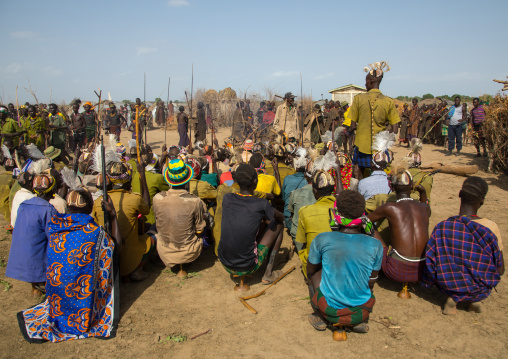 Tribe warriors during the proud ox ceremony in the Dassanech tribe waiting to share the cow meat, Turkana County, Omorate, Ethiopia