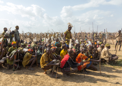 Tribe warriors during the proud ox ceremony in the Dassanech tribe waiting to share the cow meat, Turkana County, Omorate, Ethiopia