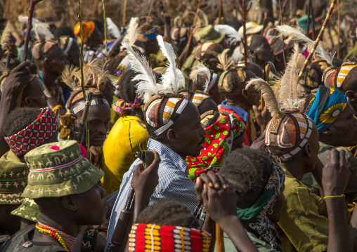 Tribe warriors during the proud ox ceremony in the Dassanech tribe waiting to share the cow meat, Turkana County, Omorate, Ethiopia