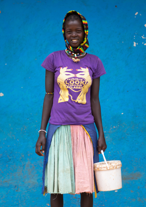 Portrait of a Bana tribe girl in front of a blue wall, Omo valley, Key Afer, Ethiopia