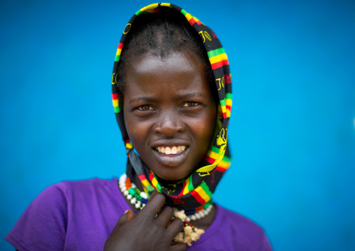 Portrait of a Bana tribe girl in front of a blue wall, Omo valley, Key Afer, Ethiopia