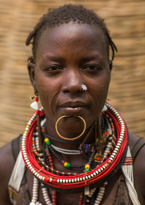 Portrait of a sudanese Toposa tribe woman refugee with huge necklaces and nose decoration, Omo Valley, Kangate, Ethiopia