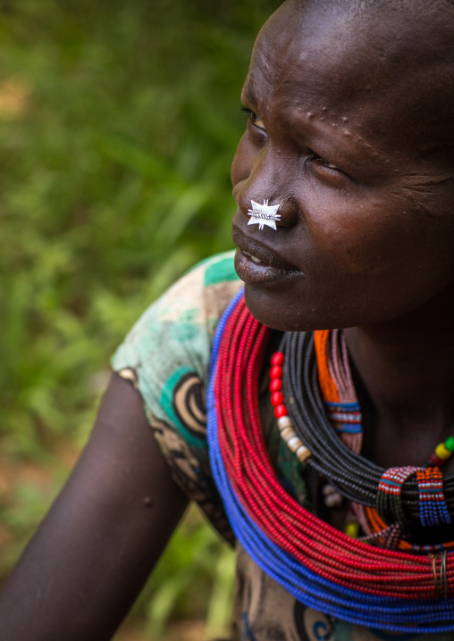 Portrait of a sudanese Toposa tribe woman refugee with huge necklaces and nose decoration, Omo Valley, Kangate, Ethiopia