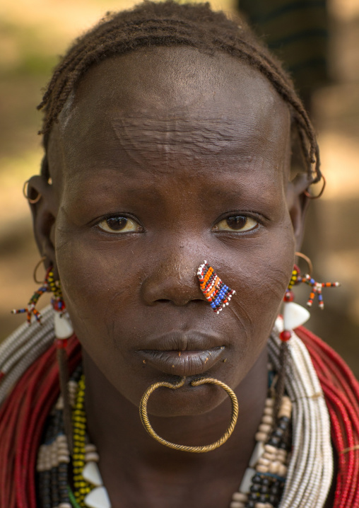 Portrait of a sudanese Toposa tribe woman refugee with nose decoration and scarifications, Omo Valley, Kangate, Ethiopia