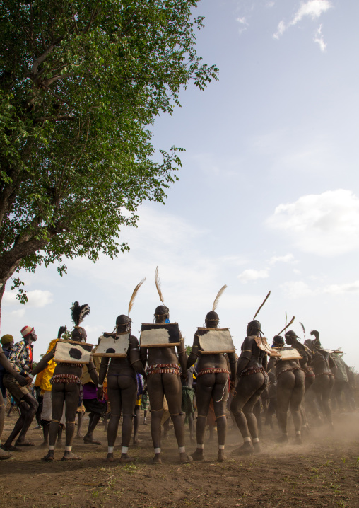 Bodi tribe fat men dancing in the dust during Kael ceremony, Omo valley, Hana Mursi, Ethiopia