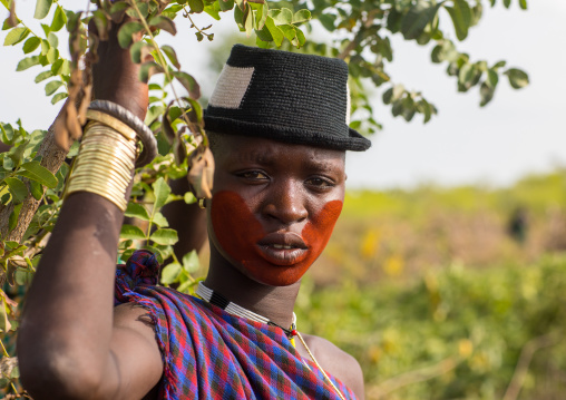 Beautiful young woman with a hat and some make up during the fat men ceremony in the Bodi tribe, Omo valley, Hana Mursi, Ethiopia