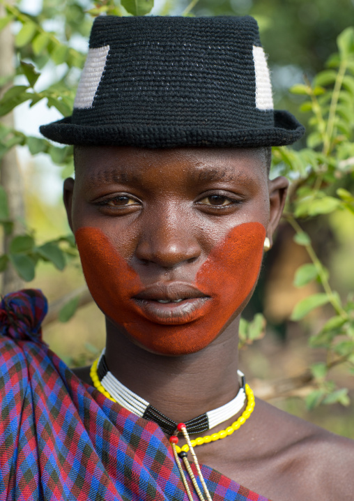 Beautiful young woman with a hat and some make up during the fat men ceremony in the Bodi tribe, Omo valley, Hana Mursi, Ethiopia