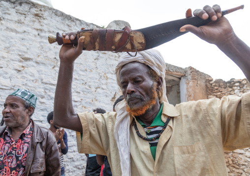 Harari man dancing with a huge knife during a sufi celebration, Harari Region, Harar, Ethiopia