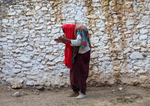 Sufi woman with a red veil into trance during a muslim ceremony, Harari Region, Harar, Ethiopia