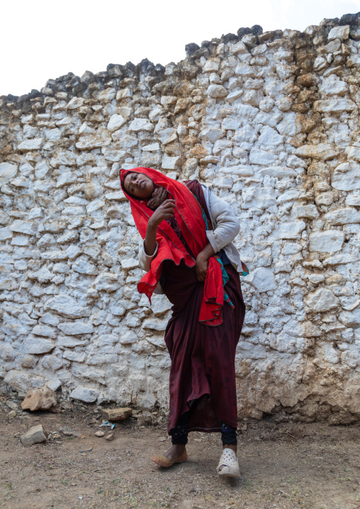 Sufi woman with a red veil into trance during a muslim ceremony, Harari Region, Harar, Ethiopia