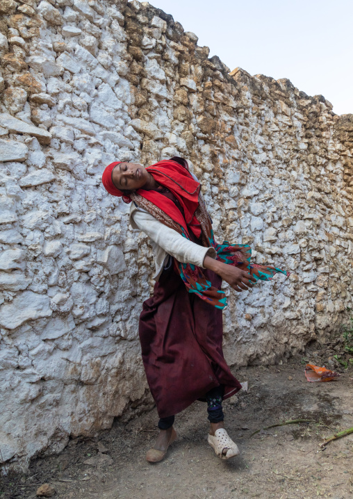 Sufi woman with a red veil into trance during a muslim ceremony, Harari Region, Harar, Ethiopia