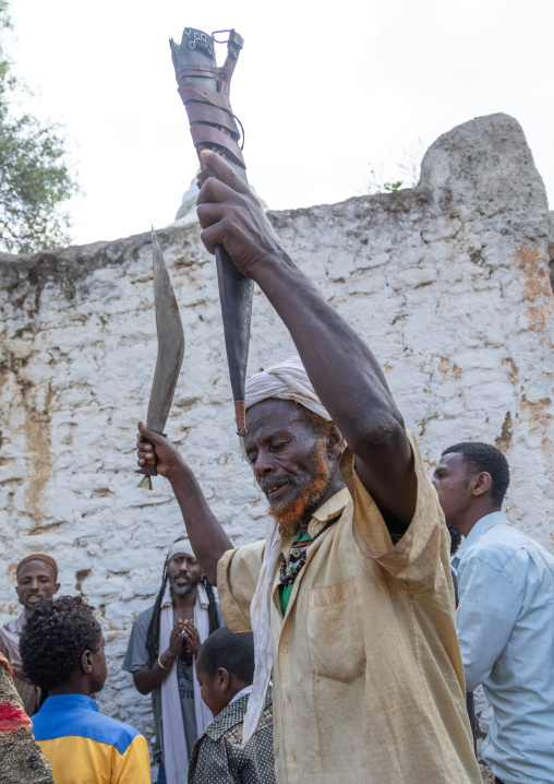 Harari man dancing with a huge knife during a sufi celebration, Harari Region, Harar, Ethiopia