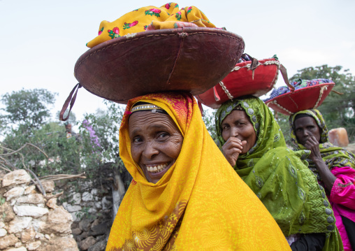 Harari women bringing injeras in baskets on their heads for a muslim celebration, Harari Region, Harar, Ethiopia