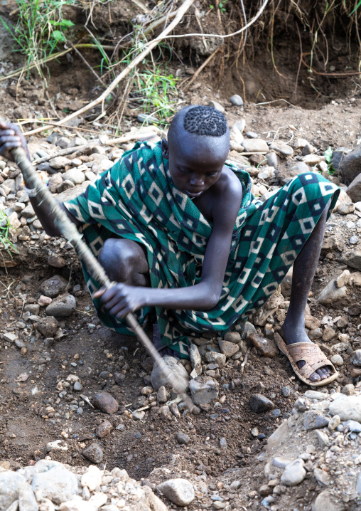 Suri tribe girls doing gold panning in a river, Omo valley, Kibish, Ethiopia