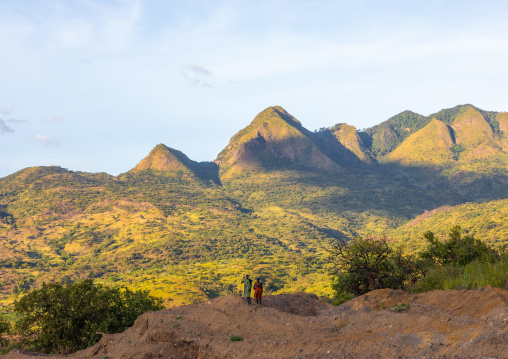 Suri tribe couple in front of a mountain landscape, Omo valley, Kibish, Ethiopia