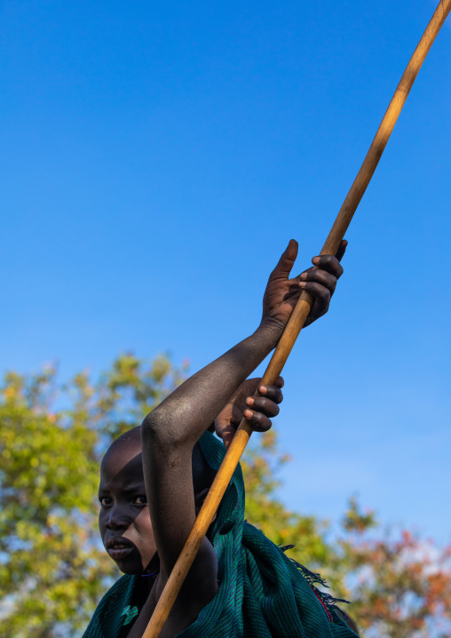 Suri tribe boy with a stick during a donga ritual, Omo valley, Kibish, Ethiopia