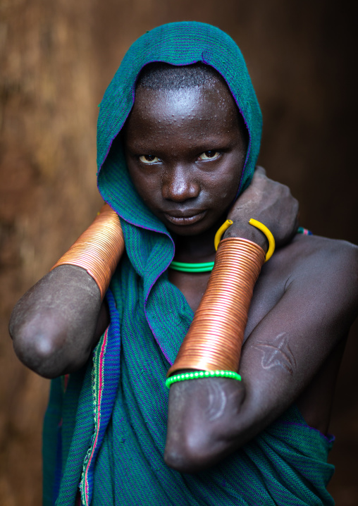 Portrait of a suri tribe young woman with impressive bracelets, Omo valley, Kibish, Ethiopia