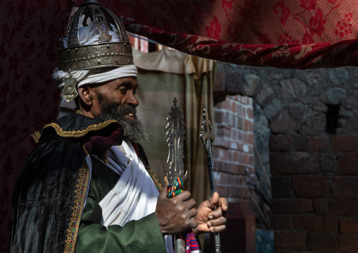 Ethiopian orthodox priest in nakuto lab rock church holding a cross, Amhara Region, Lalibela, Ethiopia