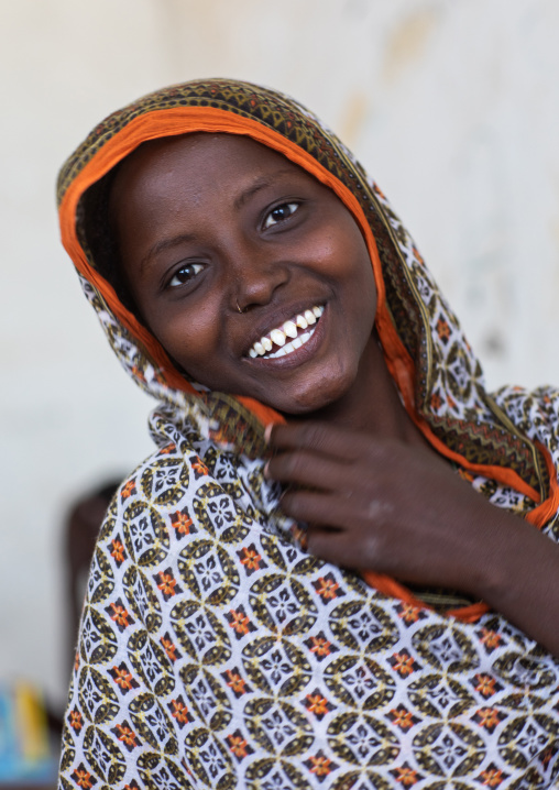 Portrait of a veiled smiling afar tribe girl with sharpened teeth, Afar Region, Afambo, Ethiopia