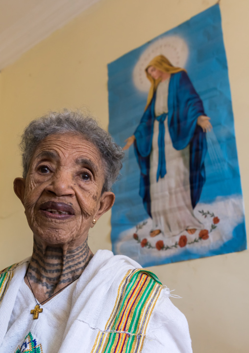 Ethiopian woman in her bedroom below a virgin mary poster, Addis Ababa Region, Addis Ababa, Ethiopia