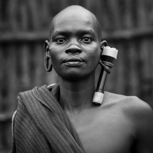 Suri tribe man with an enlarged ear decorated with a lamp, Kibish, Omo valley, Ethiopia