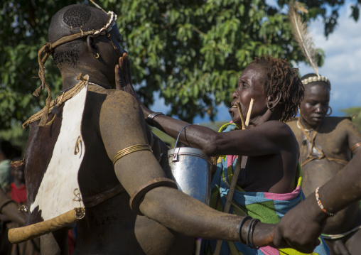 Bodi Tribe Woman Putting Water On The Face Of A Fat Man During Kael Ceremony, Hana Mursi, Omo Valley, Ethiopia