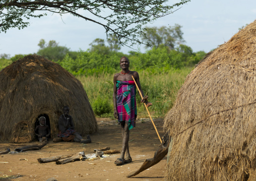 Mursi Man Standing Between Two Huts Ethiopia