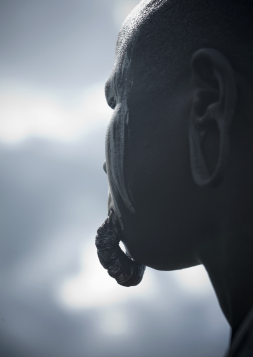 Profile Of Mursi Woman With White Paint On Face And Inferior Dilated Lip Hanging Ethiopia