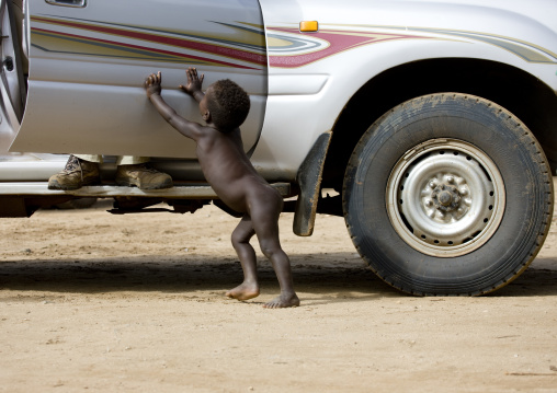 Hamer Kid Trying To Close The Door Of A Car On A Tourist, Turmi, Ethiopia