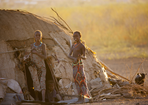 Afar girls walking out of a traditional house, Assaita, Afar regional state, Ethiopia