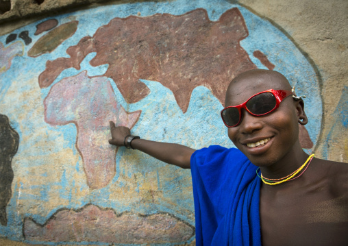 Suri man showing ethiopia on a map of africa in a school, Tulgit, Omo valley, Ethiopia