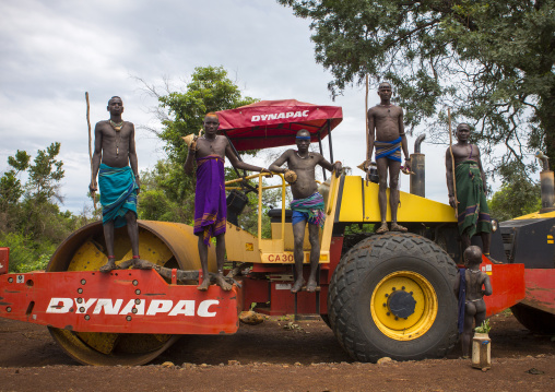 Bodi Tribe Warriors Posing Proudly On A Bulldozer Near Hana Mursi, Omo Valley, Ethiopia