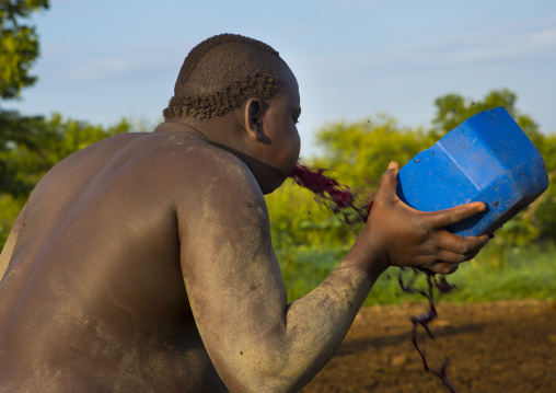 Bodi Tribe Man Spilling Out Cow Blood For New Year Kael Ceremony, Hana Mursi, Omo Valley, Ethiopia