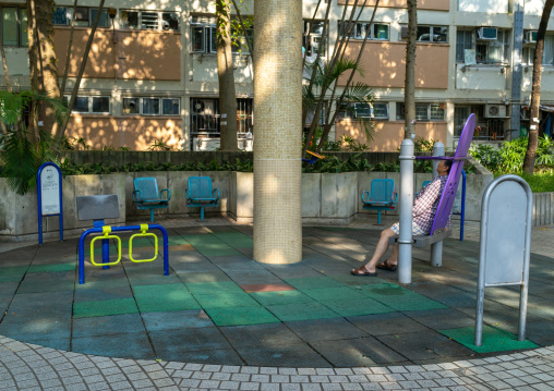 Chinese man sleeping in a playground, Kowloon, Hong Kong, China