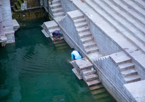 Idian men collecting water in toorji ka Jhalra stepwell, Rajasthan, Jodhpur, India