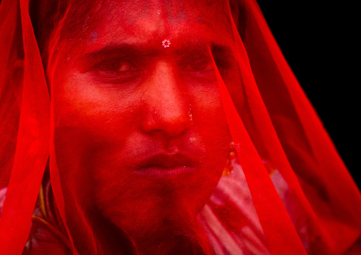 Portrait of a rajasthani woman hidding her face under a red sari, Rajasthan, Jaisalmer, India