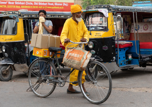 Indian priest with his bicycle in the street, Rajasthan, Bikaner, India