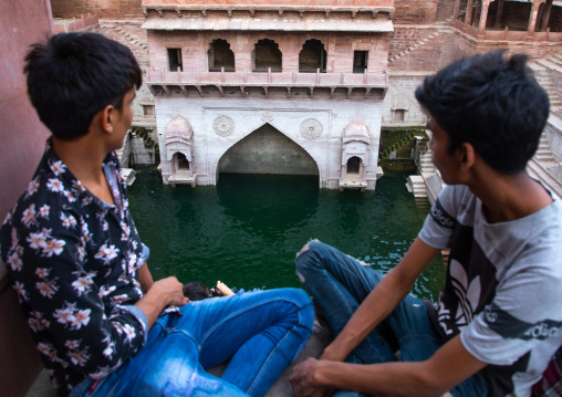 Indian boys looking at toorji ka Jhalra stepwell, Rajasthan, Jodhpur, India