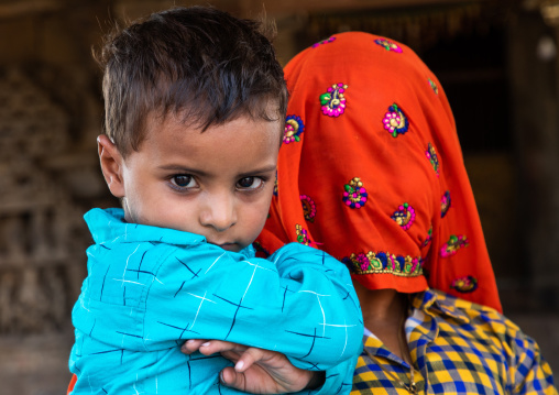 Indian mother with face covered by a sari with her son, Rajasthan, Abhaneri, India