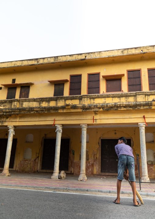 Young boy holding a cricket bat and playing in the street, Rajasthan, Jaipur, India