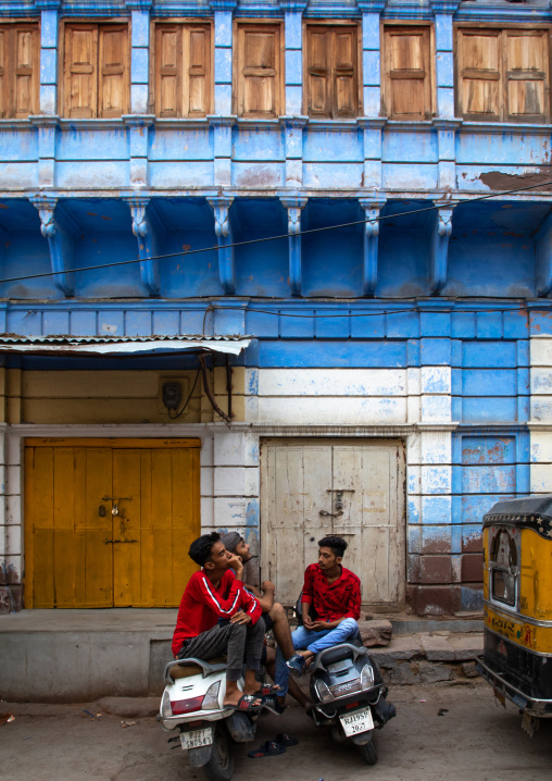 Indian men with scooters in front of old blue house of a brahmin, Rajasthan, Jodhpur, India